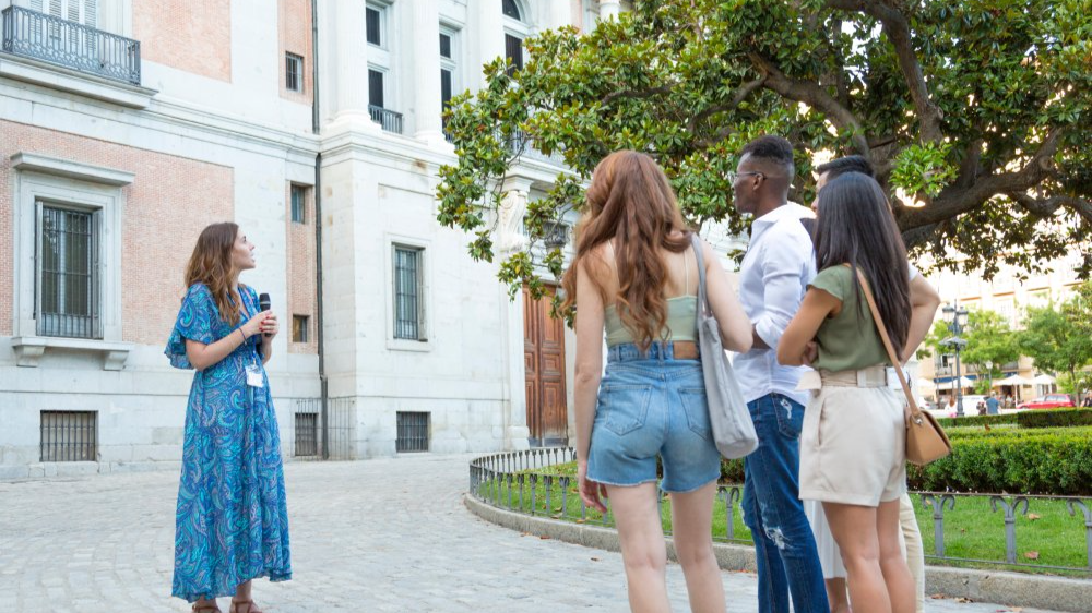 Tour guide holding a microphone during excursion with interracial tourists