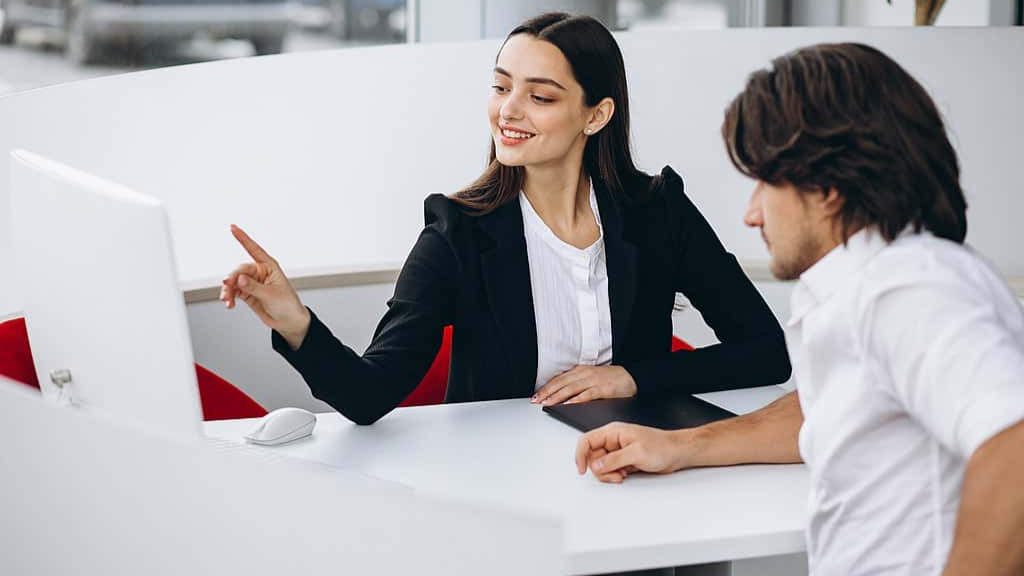 Man talking with female sales person in a car show room