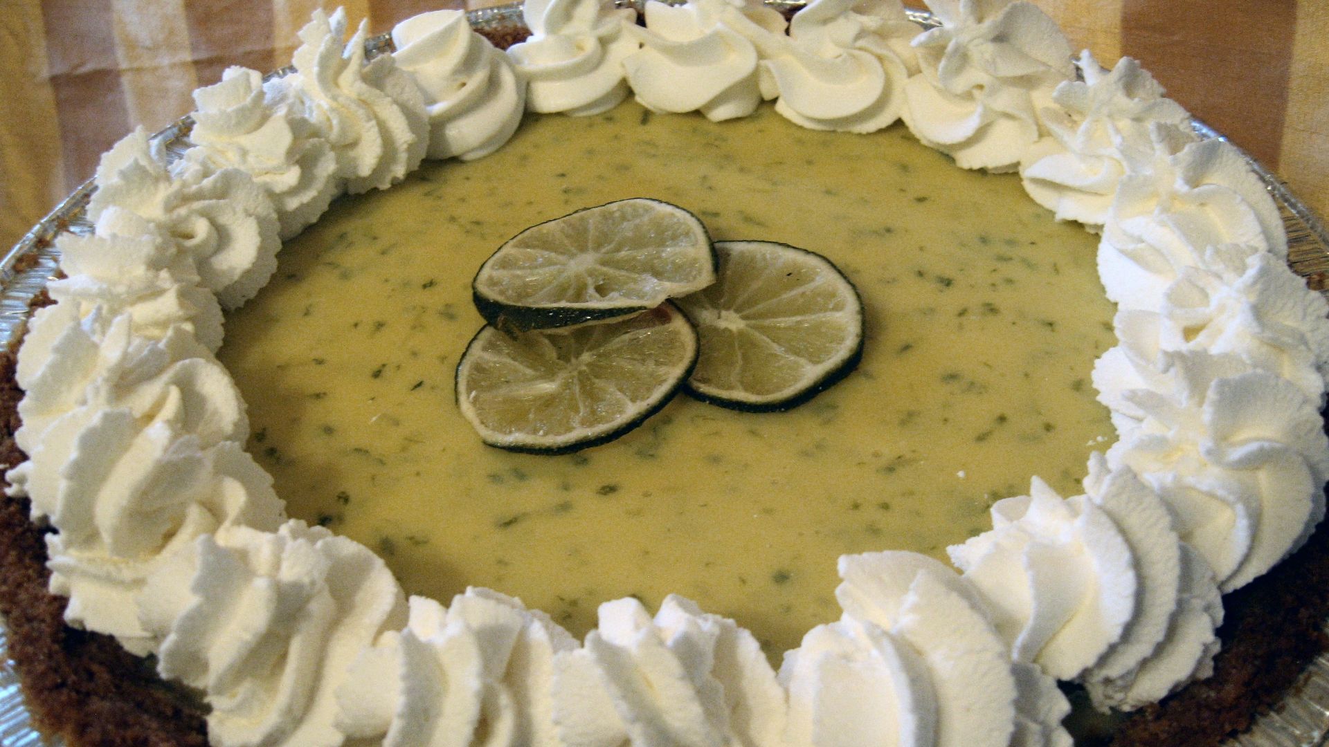 Key lime pie with whipped cream and lime decoration.