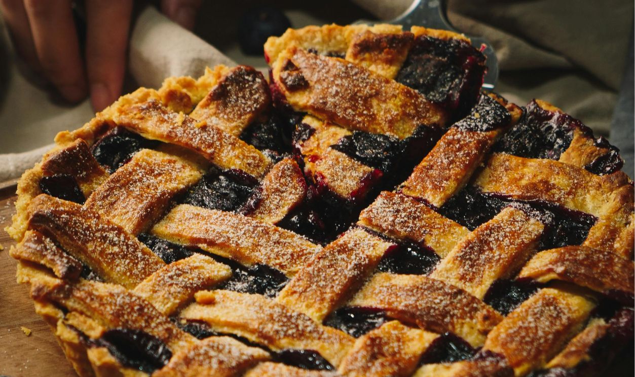 Delicious homemade blueberry pie on a wooden board, showcasing an elegant lattice crust, perfect for dessert lovers