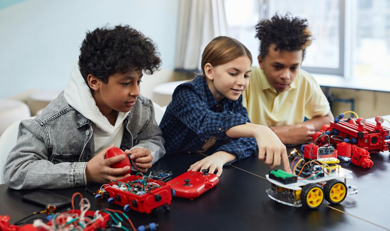 Diverse kids collaborating on robotics project, promoting STEM learning