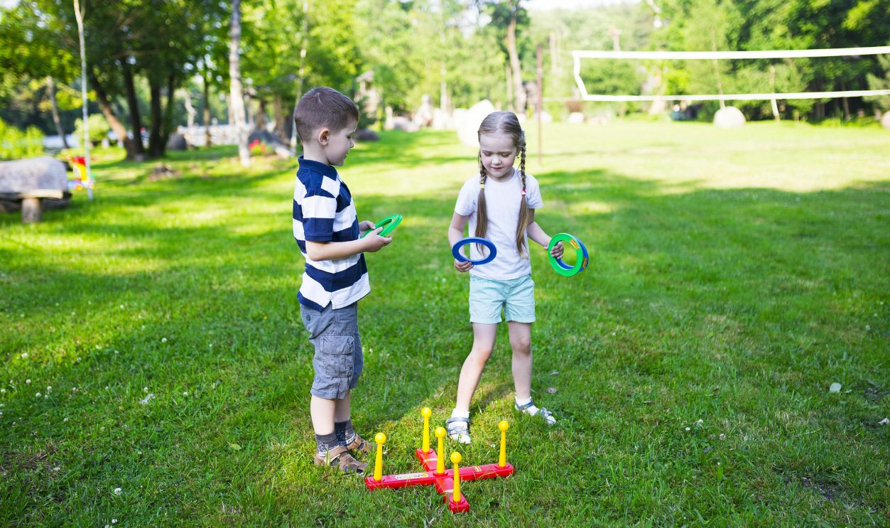 Two kids enjoying a ring toss game outdoors