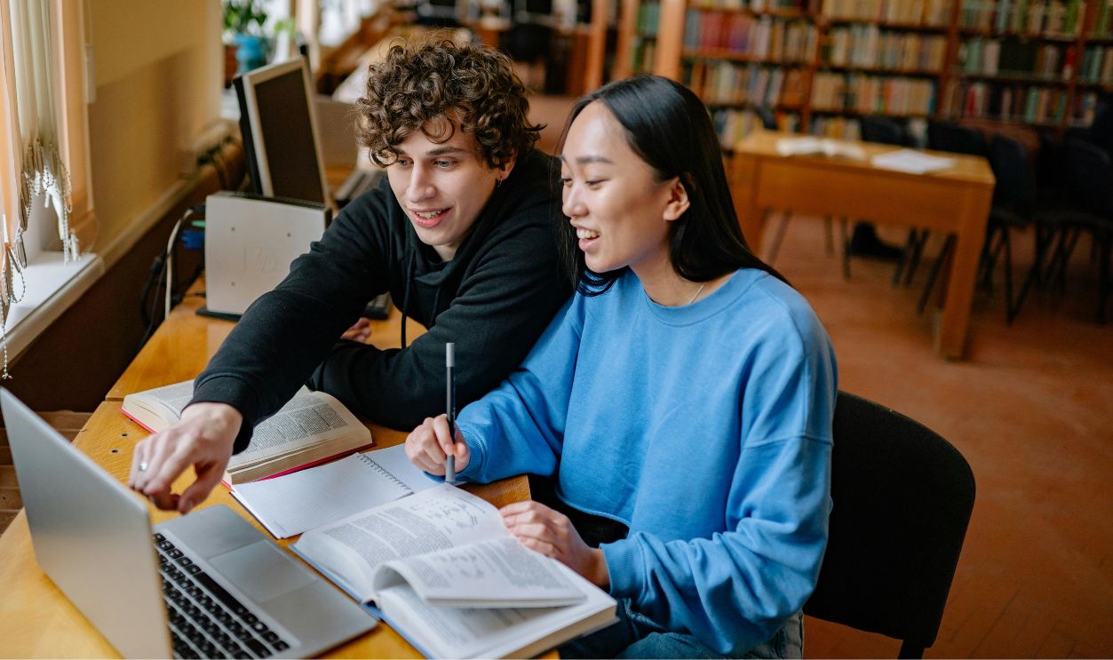 Two students studying together in a library