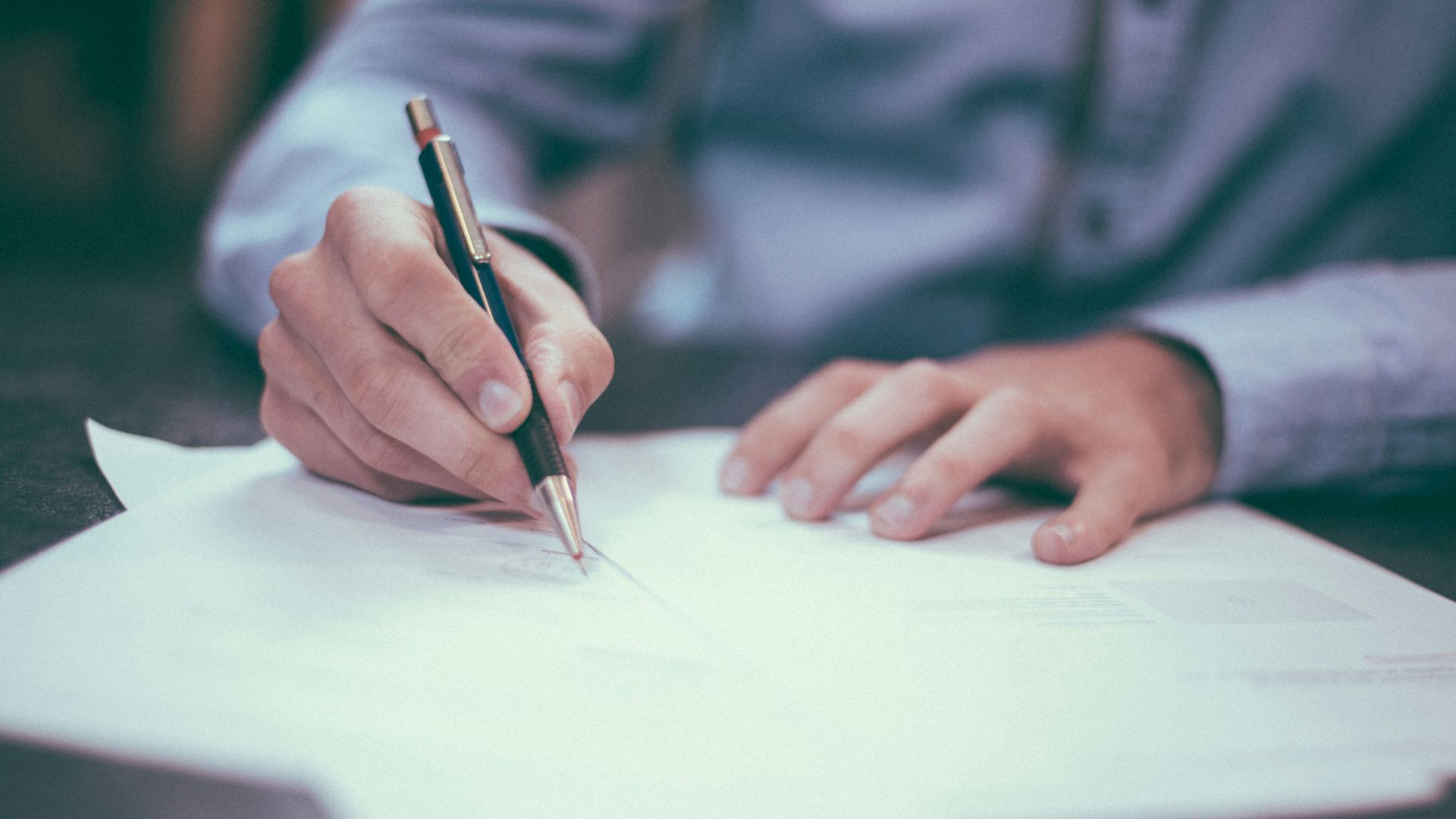 man writing on paper