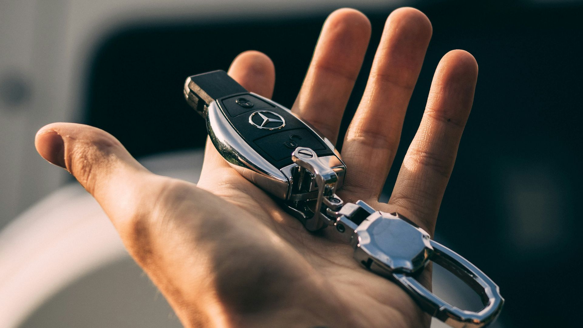 person holding Mercedes-Benz fob