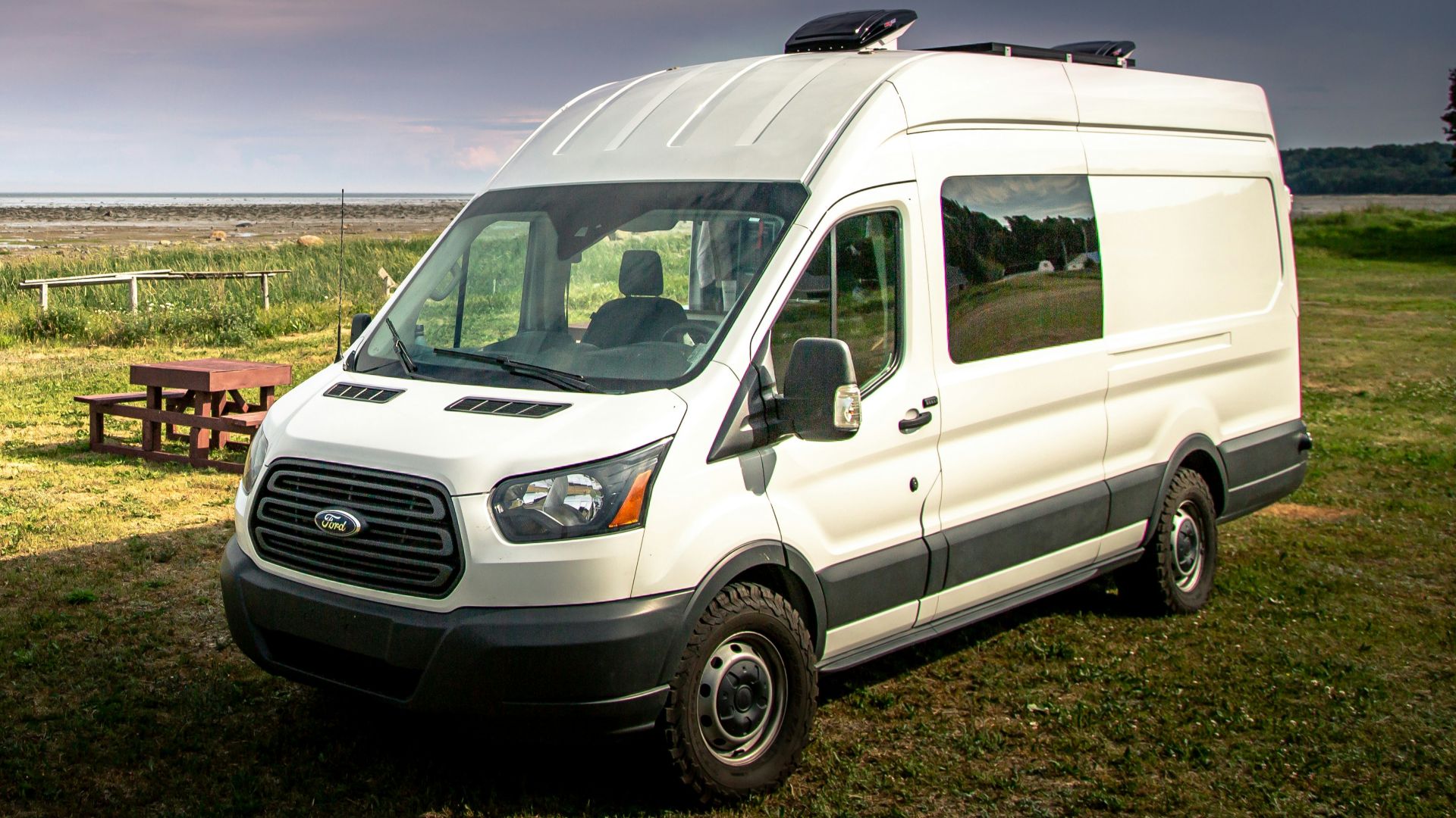 white van on green grass field during daytime