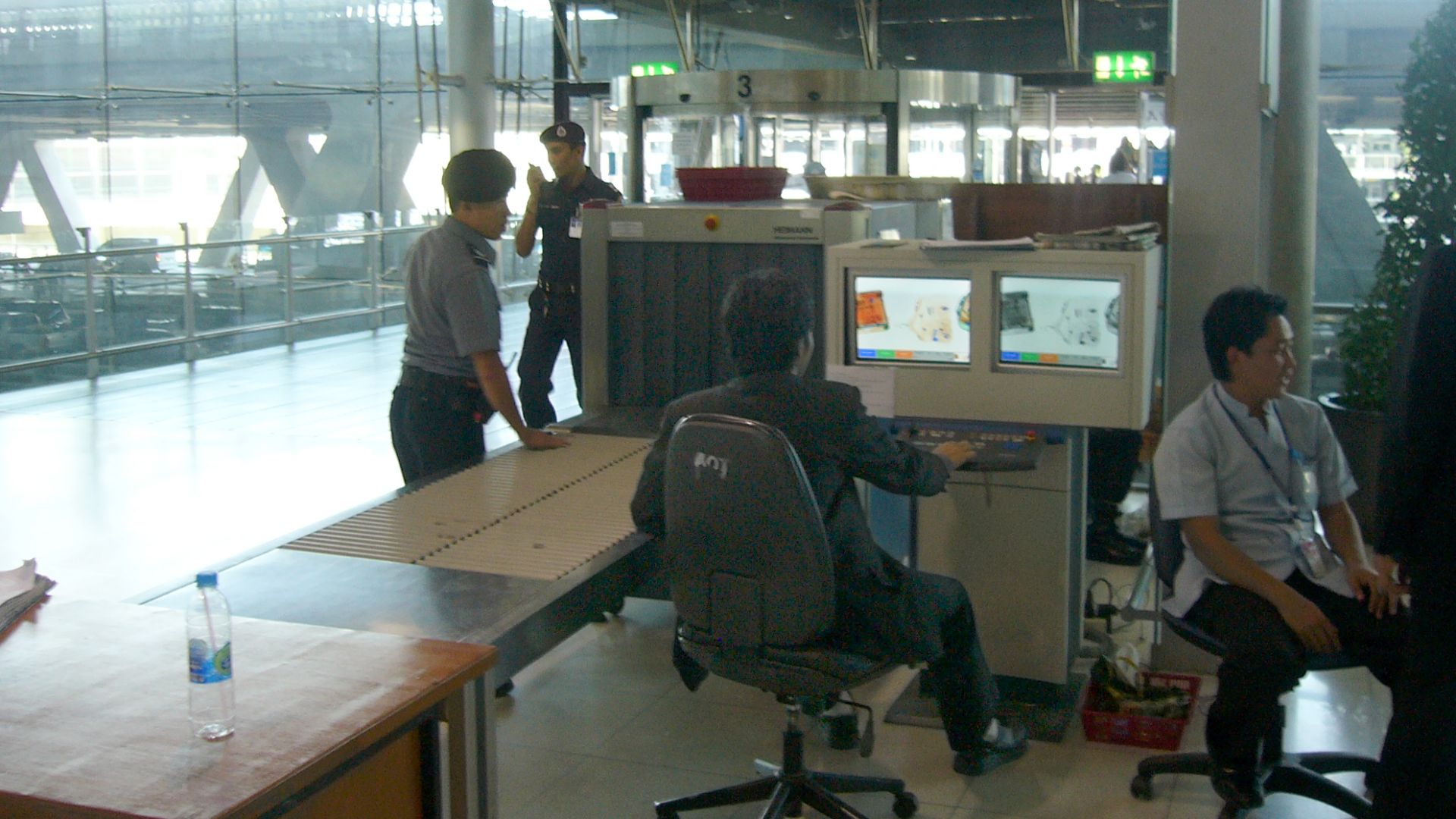 Luggage screening device at Suvarnabhumi International Airport, Bangkok, Thailand. This security post is located for entering the airport which means all people (visitors and passengers) have to pass such a control. Another control will be for boarding luggage before entering the secured area (passengers only). View towards the street.
