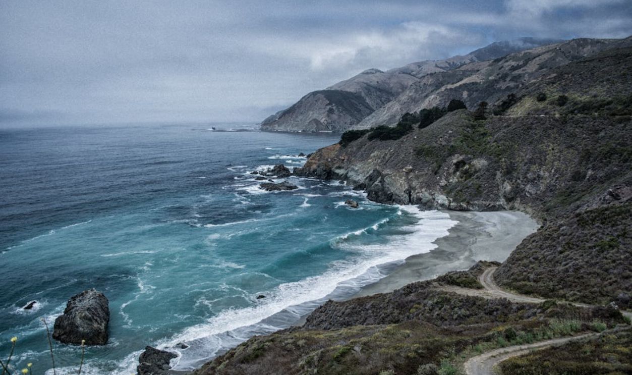 Explore the rugged beauty of a dramatic coastline with rocky cliffs and churning waves