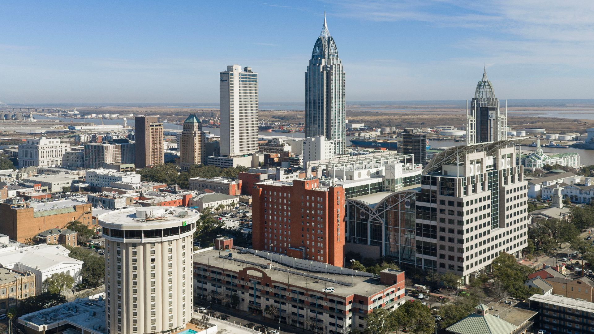 Skyline of Mobile, Alabama, viewed from the west, with downtown buildings along the Mobile River.