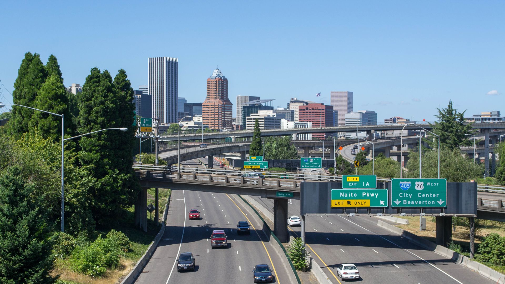 Portland seen from the westernmost section of the Ross Island Bridge, with Interstate 5 in the foreground and the viaducts of the southern I-5/I-405 interchange in the center of the view