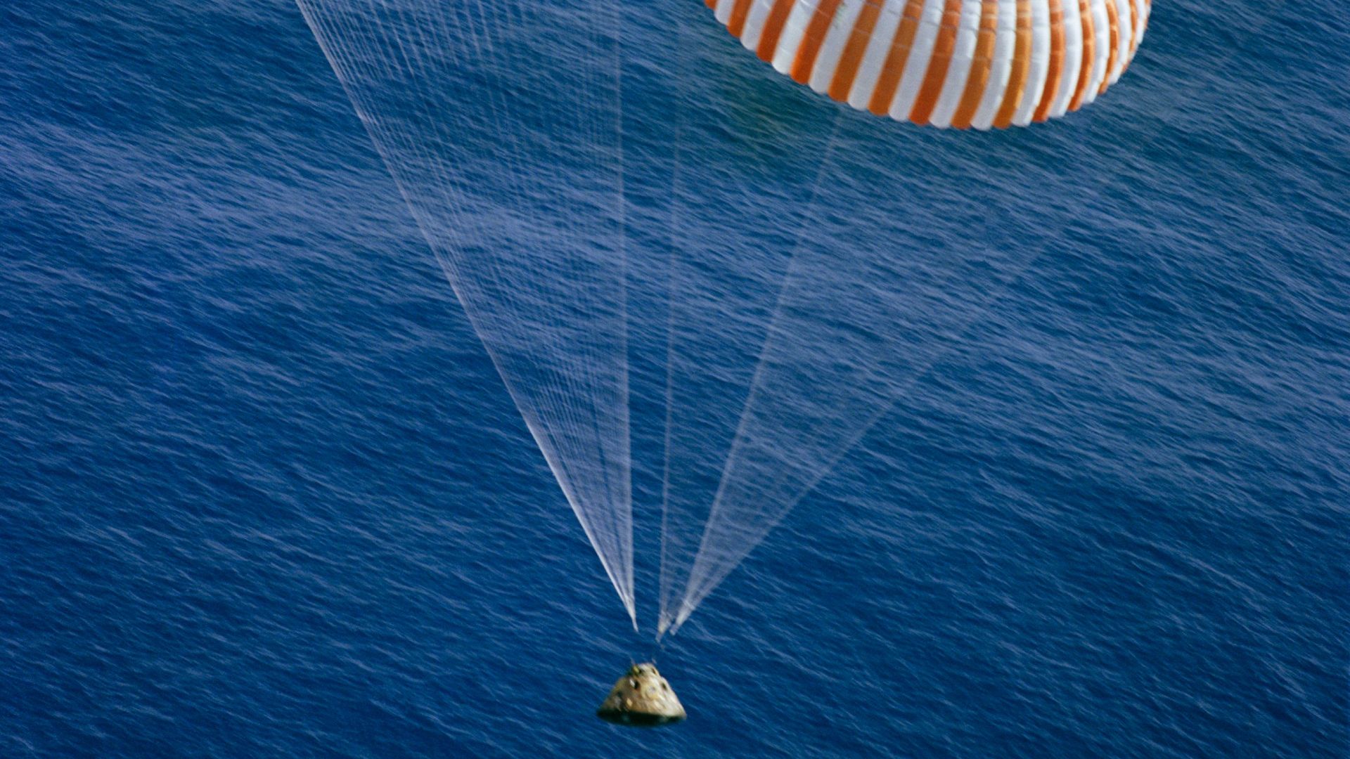 The Apollo 17 Command Module (CM), with astronauts Eugene A. Cernan, Ronald E. Evans and Harrison H. Schmitt aboard, nears splashdown in the South Pacific Ocean to successfully concludes the final lunar landing mission in NASA's Apollo program. This overh