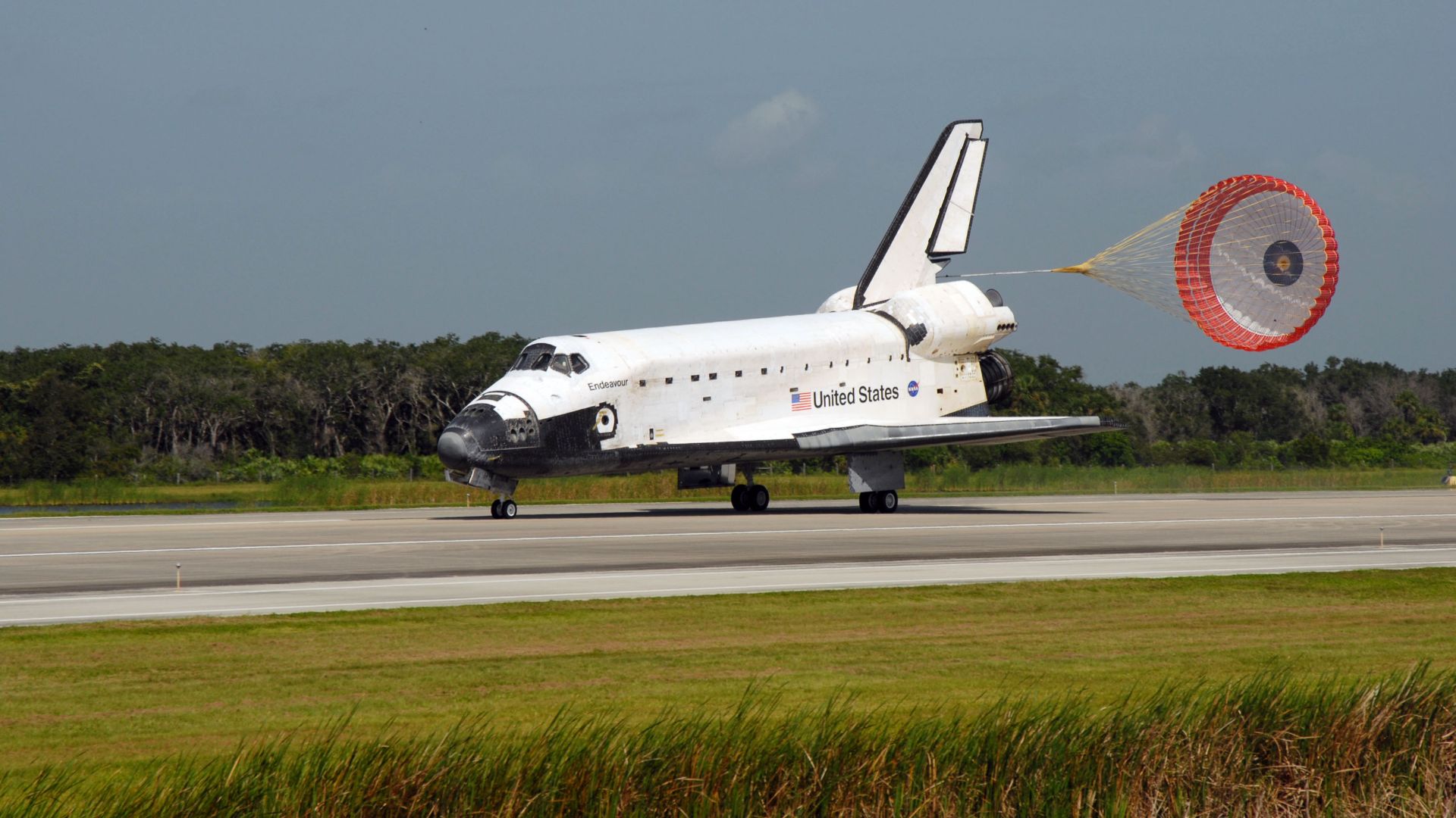 Space Shuttle Endeavour's drag chute is deployed as the spacecraft rolls toward wheels stop on Runway 15 of the Shuttle Landing Facility at NASA's Kennedy Space Center, concluding the 16-day, 6.5 million mile journey on the STS-127 mission to the Internat