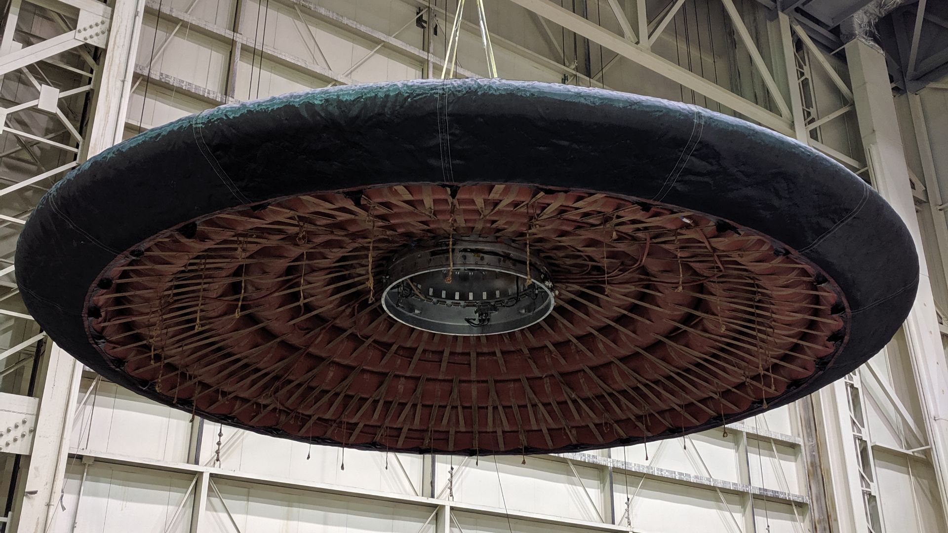 Team members work on the underside of an inflatable aeroshell that will be tested in November 2022 during the Low-Earth Orbit Flight Test of an Inflatable Decelerator, or LOFTID, technology demonstration.