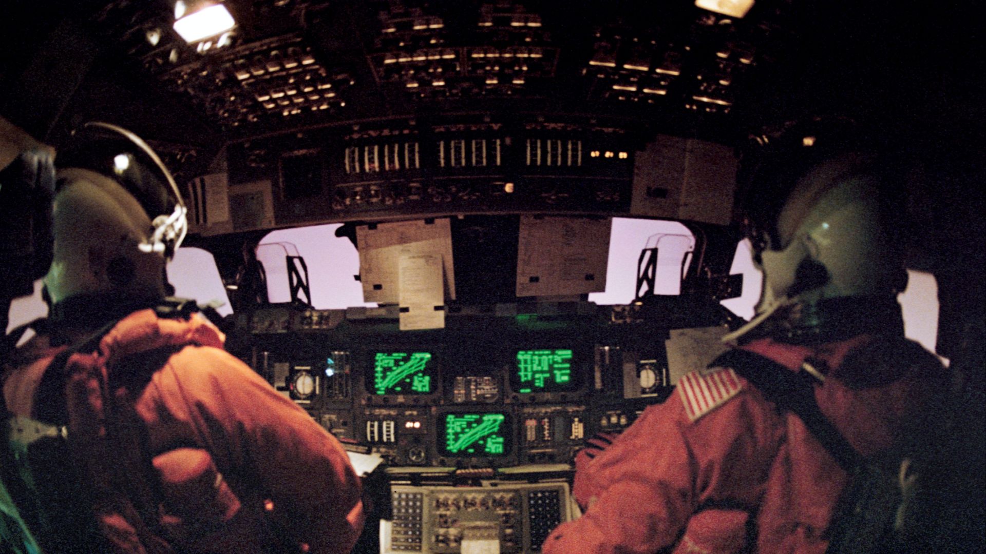 Front deck astronaut view of the Space Shuttle re-entering the atmosphere on STS-42 in January 1992. The pinkish glow outside the windows (true color) is the plasma from aerodynamic heat friction.