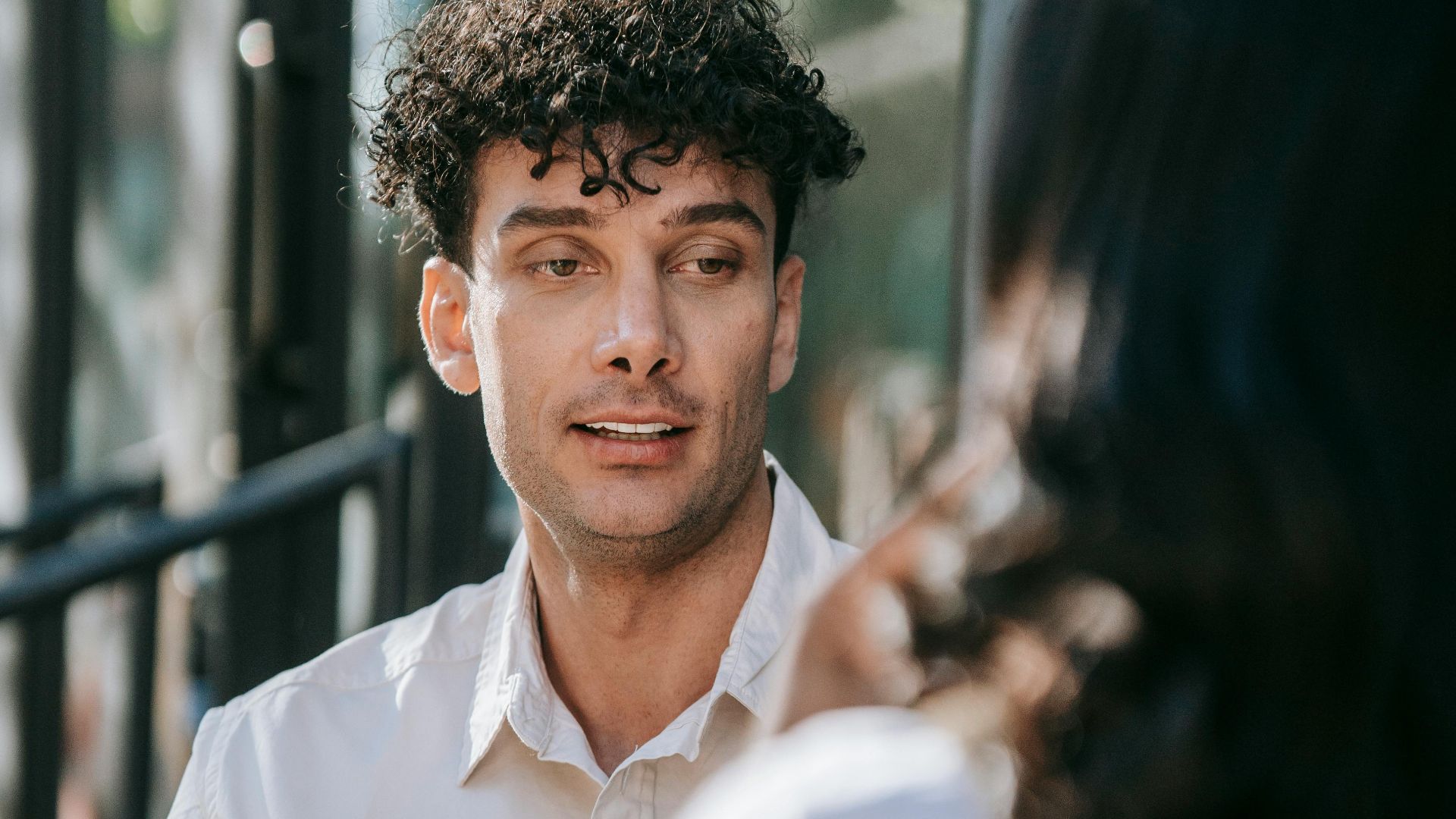Two people enjoying a conversation with coffee at an outdoor cafe.