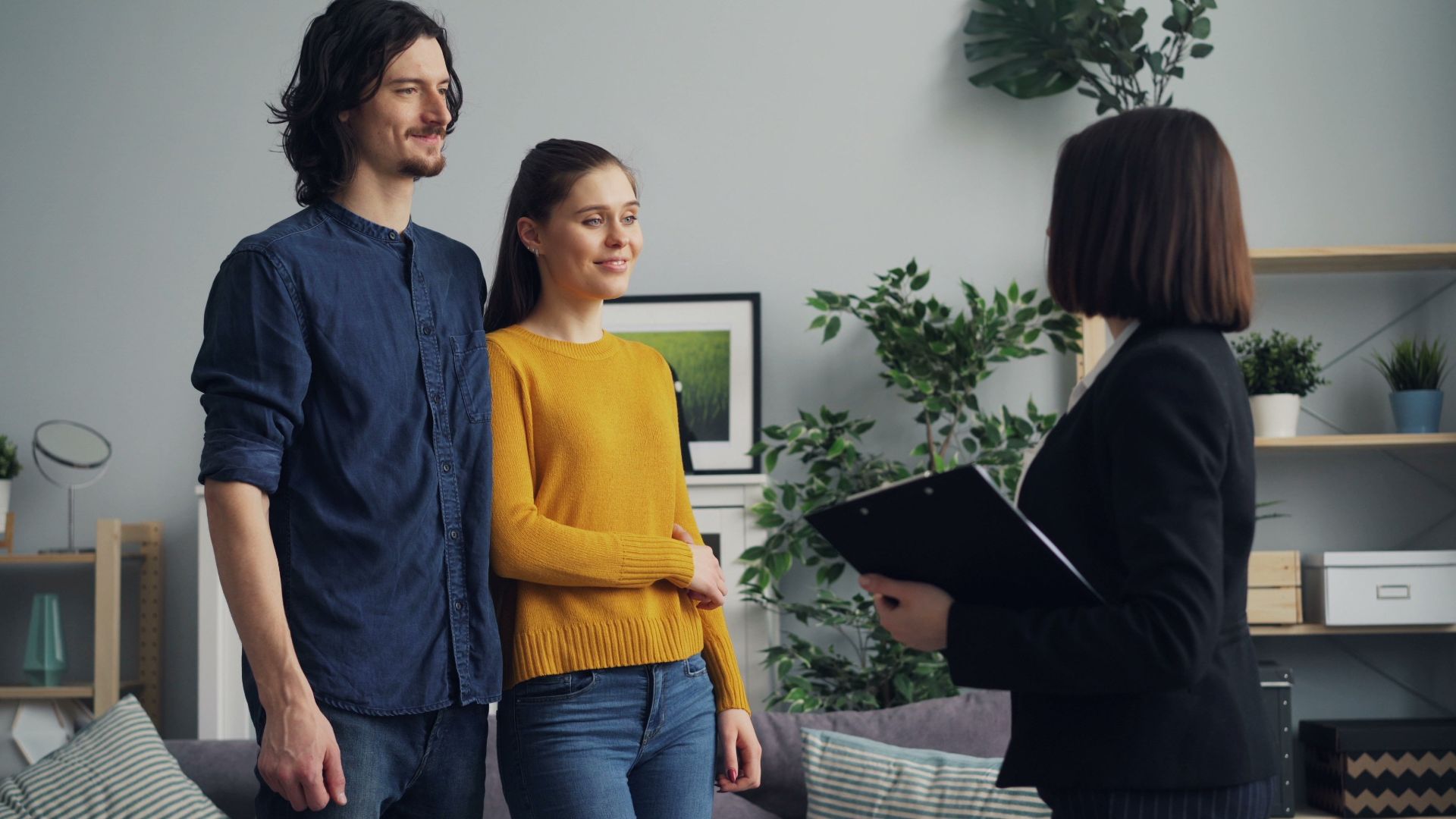 A couple engages with a real estate agent inside a modern living space.
