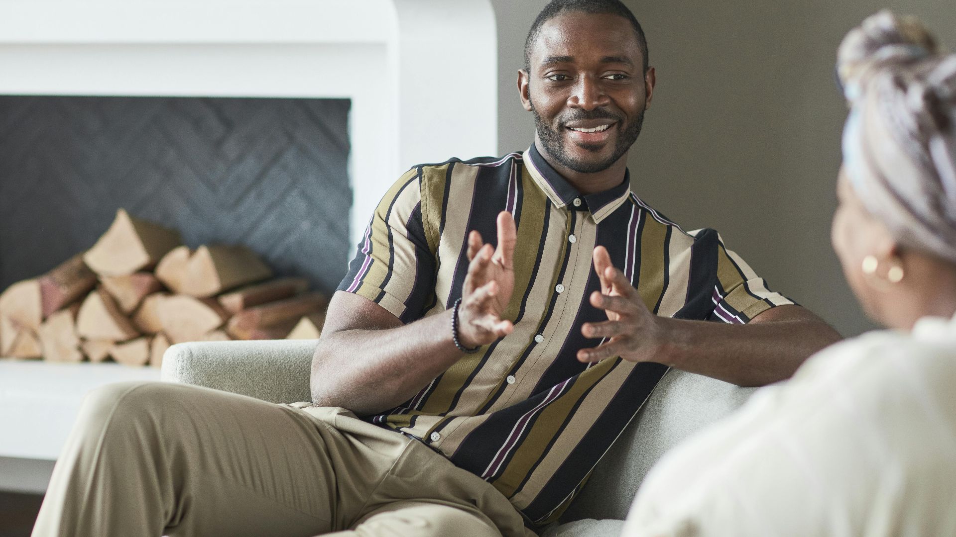 Two adults enjoying a friendly conversation in a cozy modern living room setting.