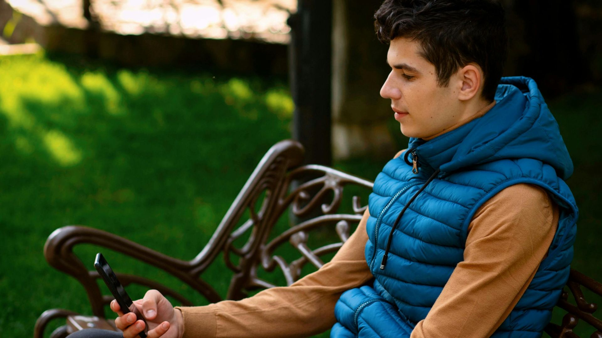 Teenage boy using smartphone outdoors in Pitești, Romania.