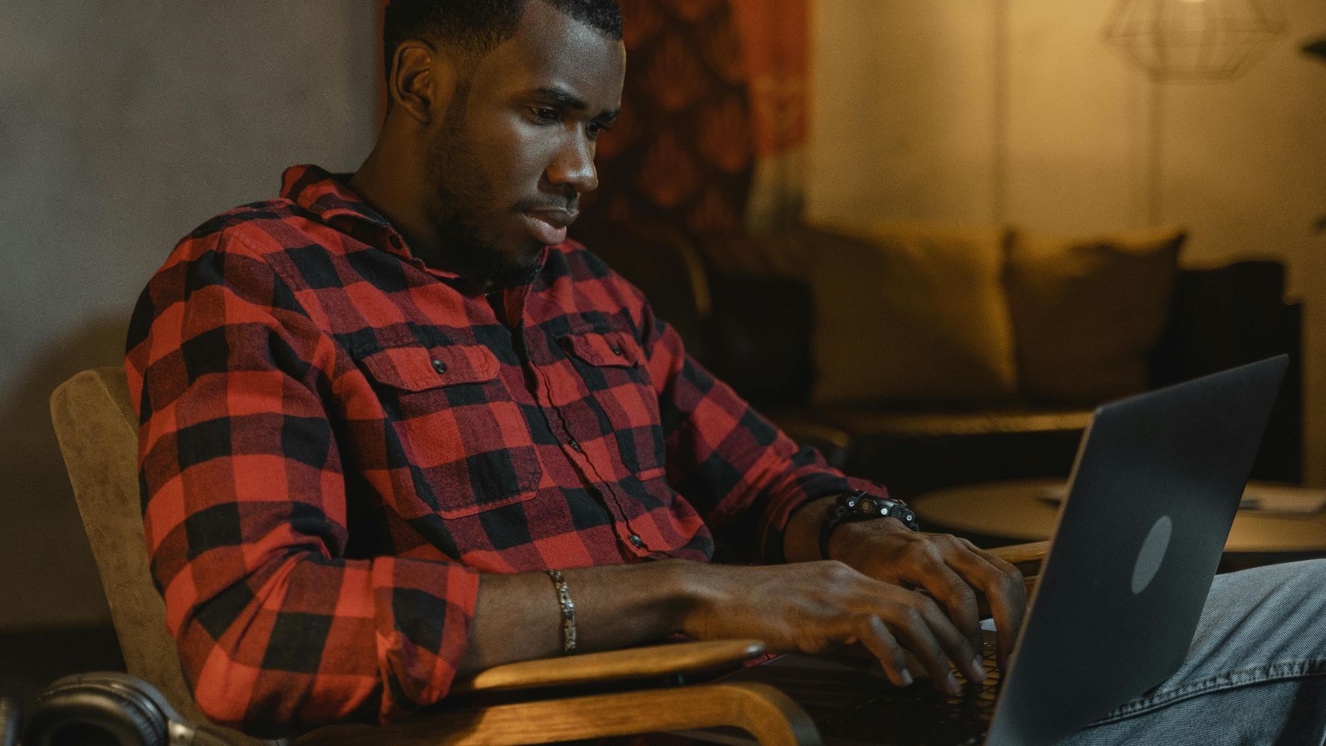 Contemporary scene of a man working on a laptop in a cozy home environment, highlighting remote work lifestyle.