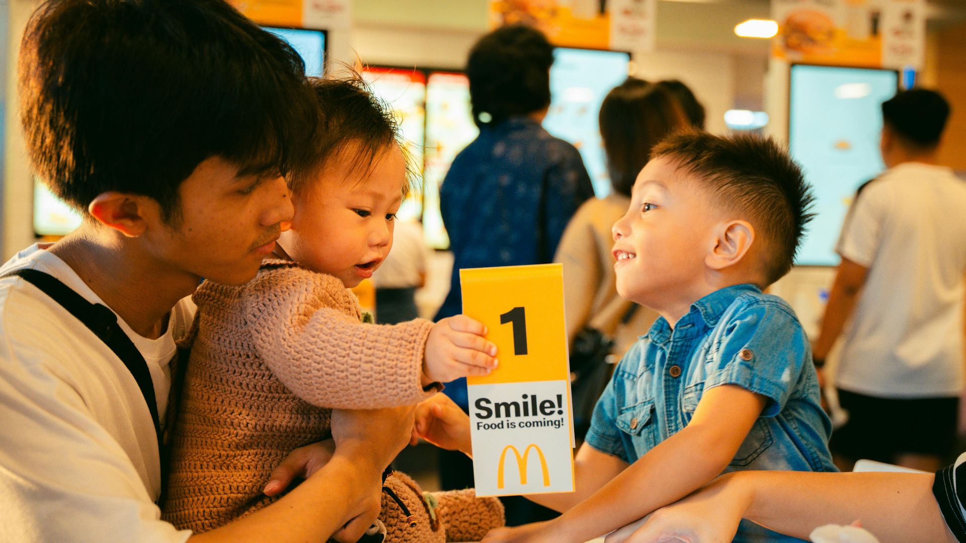 Father and children sharing a joyful moment at a fast food restaurant.