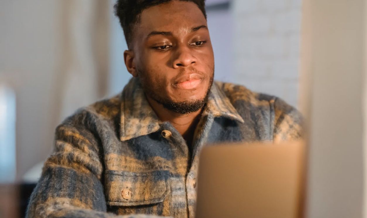 Attentive African American man concentrating on his laptop screen in a cozy home setting