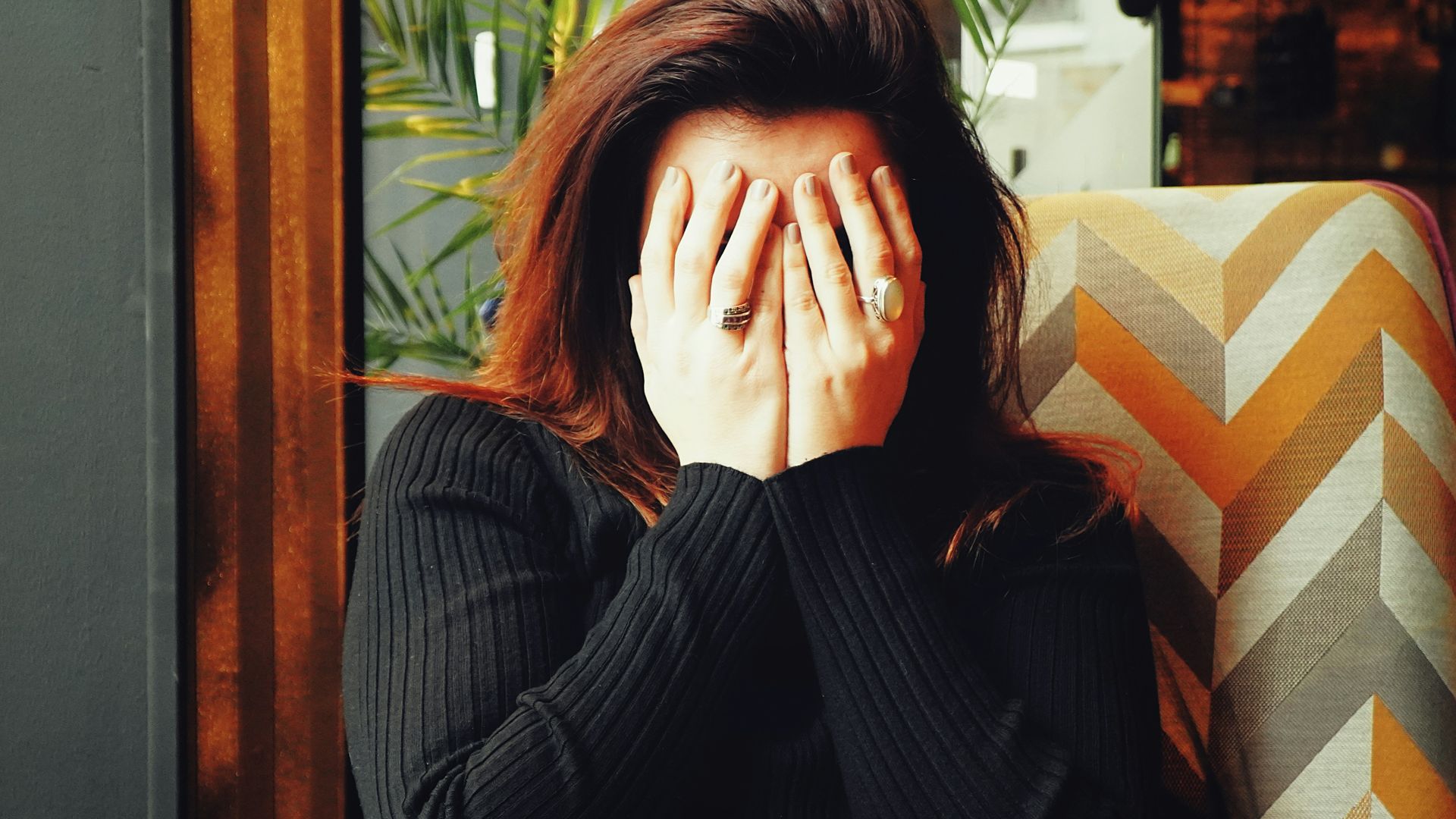 woman in black long sleeve shirt covering her face