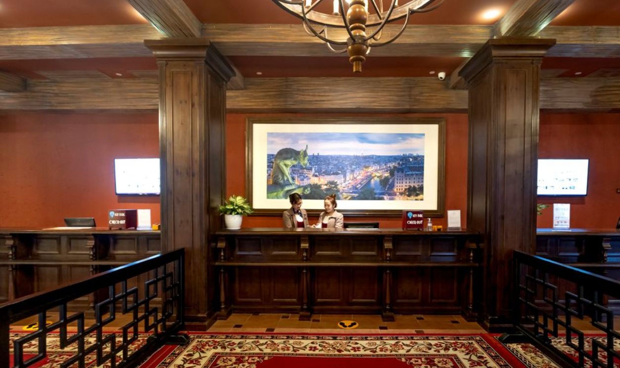 Elegant and luxurious hotel reception with classic wooden design and plush carpeting.