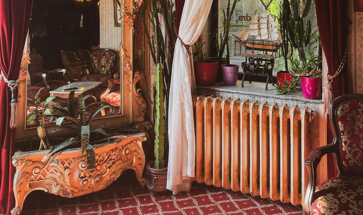 Elegant vintage hotel room with ornate mirror and red curtains in Istanbul.