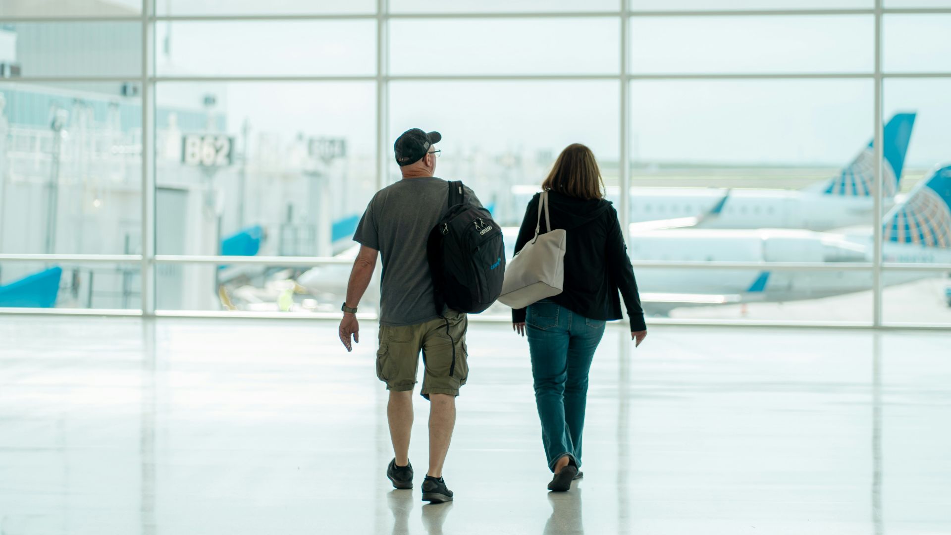 a man and a woman walking through an airport
