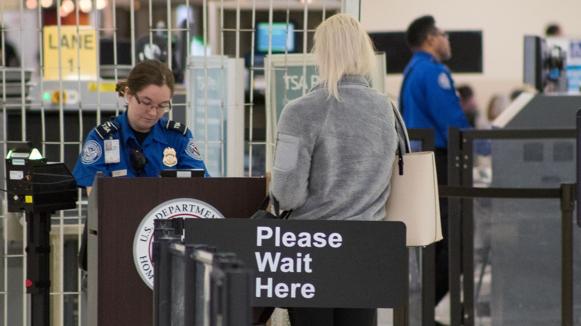 A Transportation Security Administration agent at a checkpoint verifying passenger identification, John Glenn Columbus International Airport