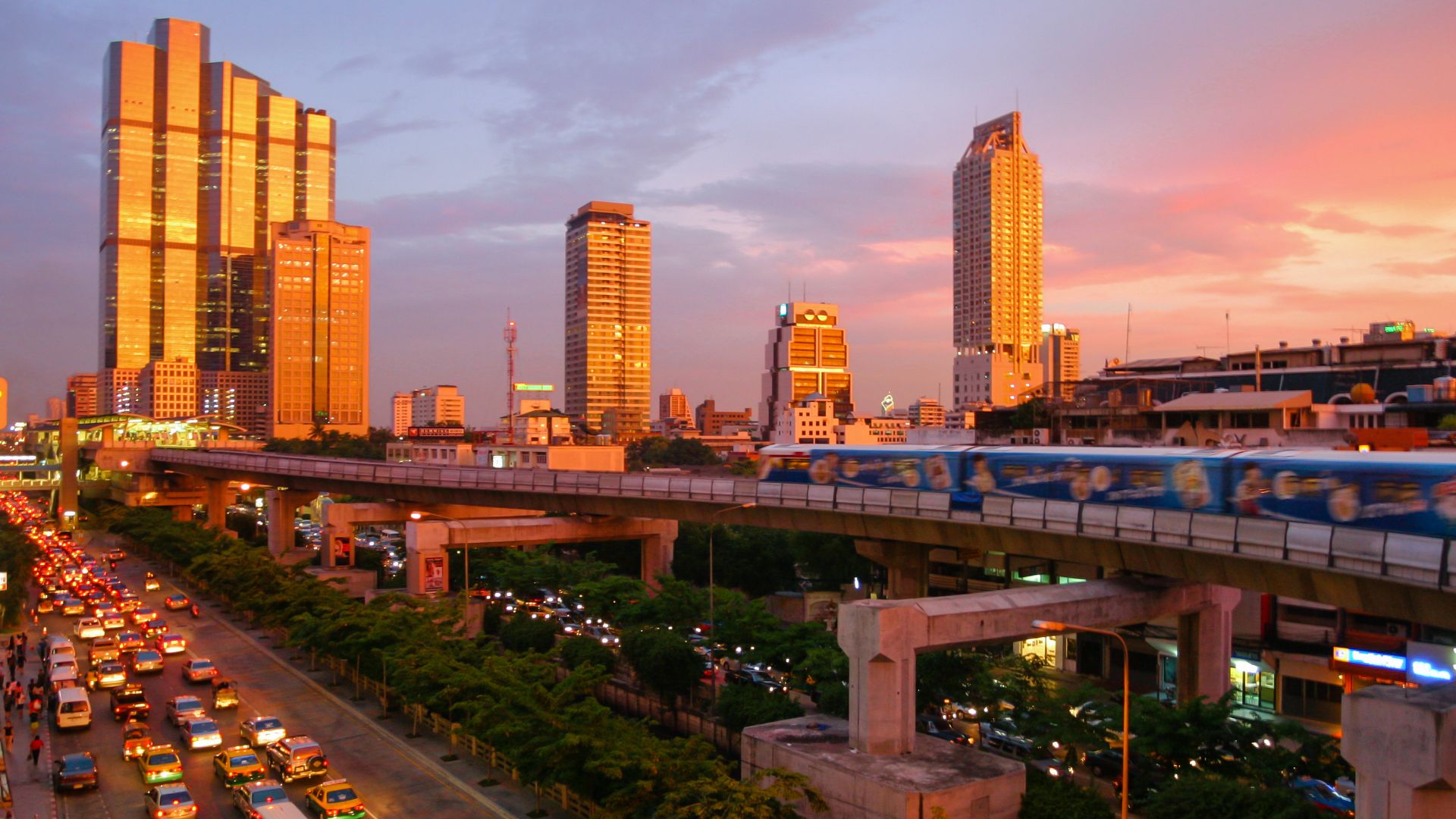 A spectacular sunset in Bangkok, showing the skytrain and modern skyline down Thanon Naradhiwas Rajanagarindra, taken from the corner of Thanon Silom, with the Empire Tower and the Chong Nonsi BTS Station at the left side.