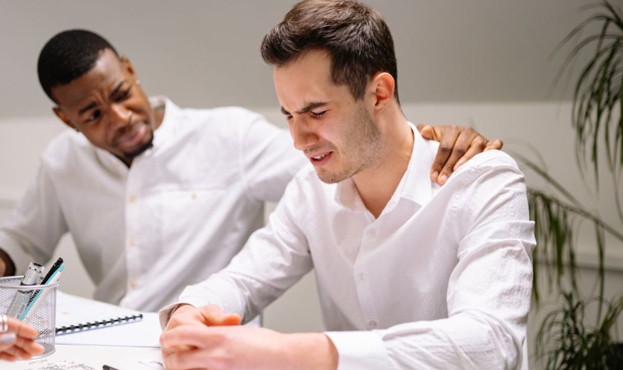 Coworkers showing emotional support in a modern office environment