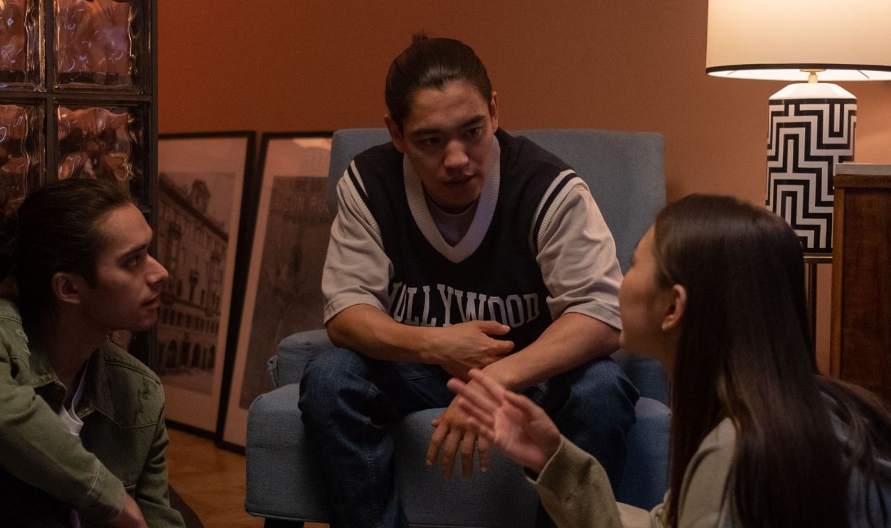 Three teenagers sitting indoors, discussing in a cozy setting with modern decor
