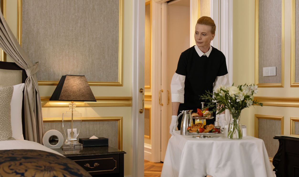 Chambermaid delivering luxury room service breakfast to a stylish hotel room, exuding comfort and hospitality.
