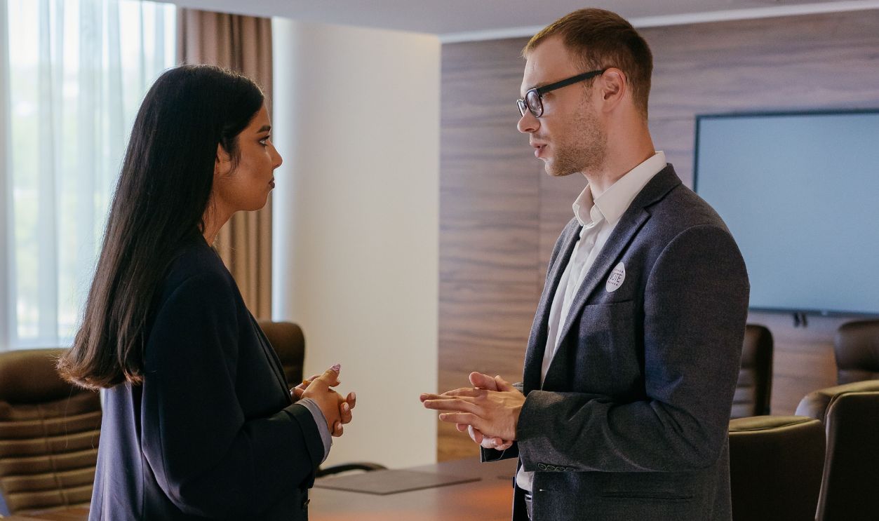 Two professionals engaged in discussion inside a modern conference room