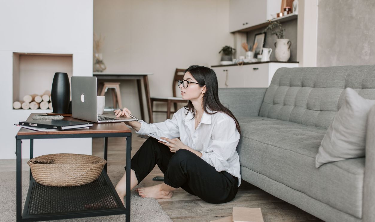 Asian woman working on laptop from cozy living room, showcasing modern home
