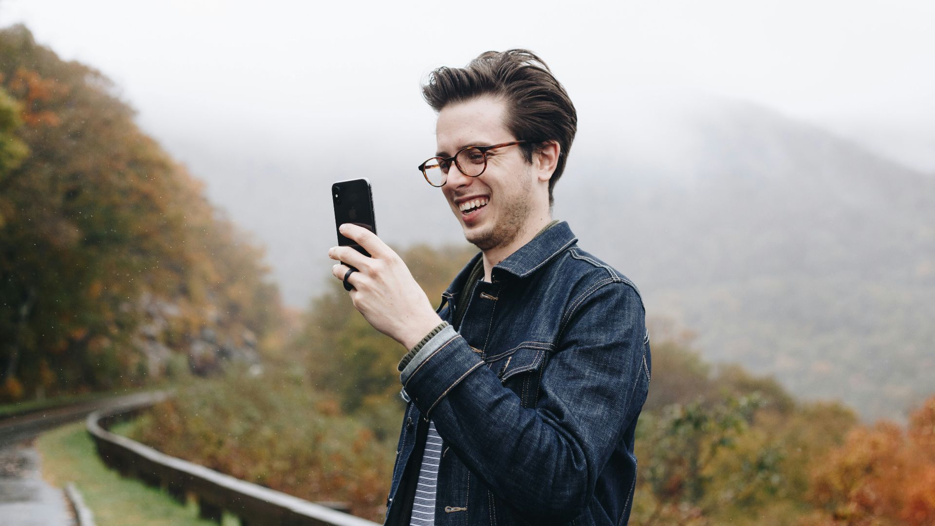 smiling man looking at his smartphone