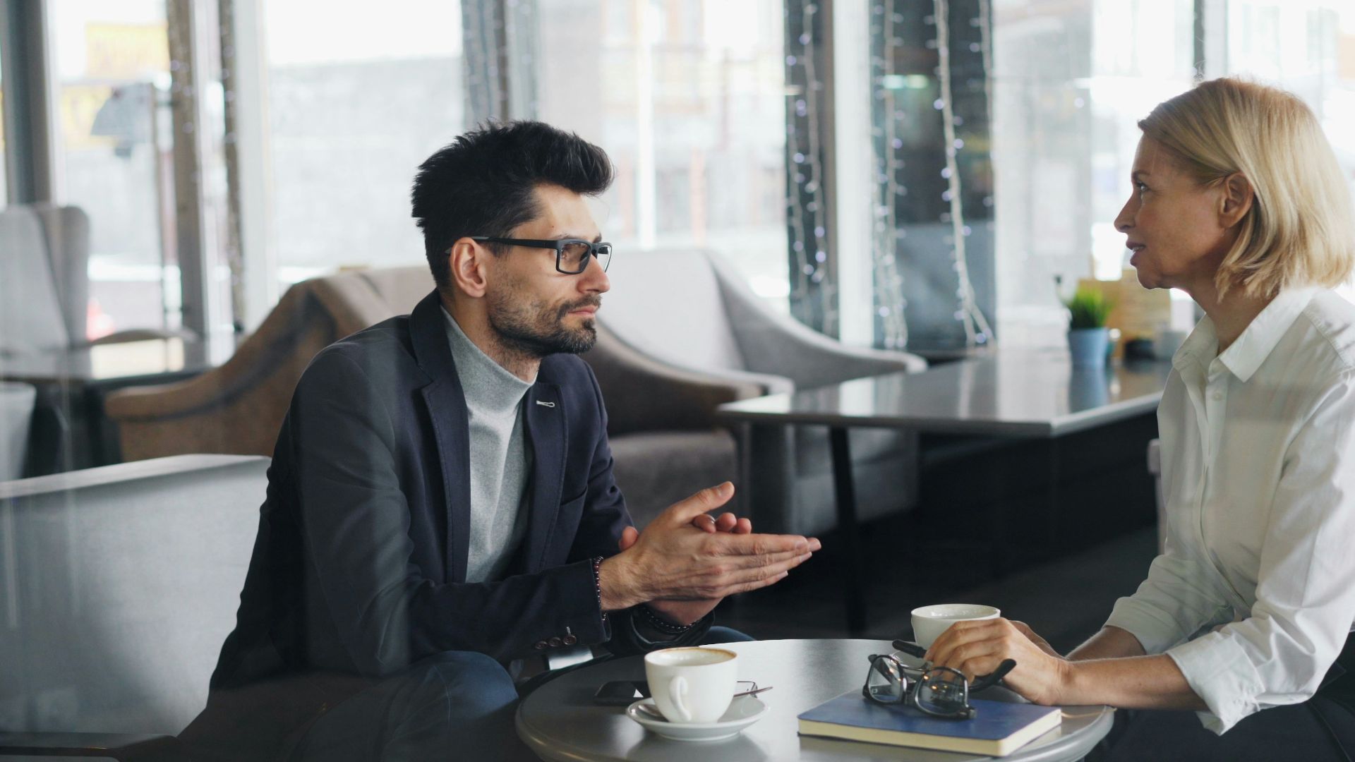 a man and a woman sitting at a table talking