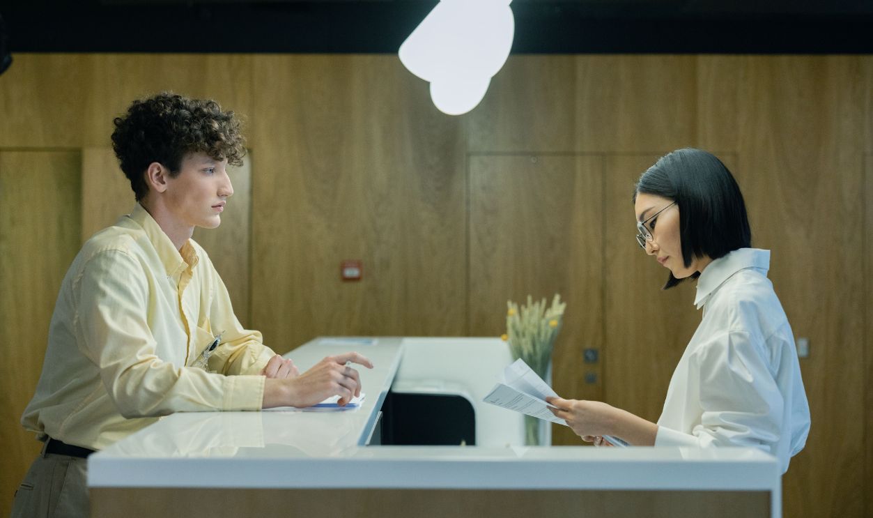 A young man and woman interacting at a modern office reception
