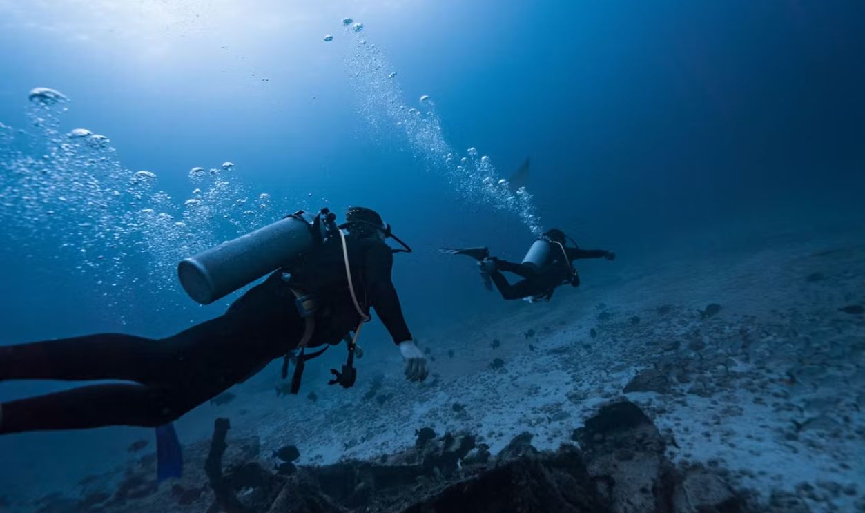 Scuba divers exploring the underwater world in Isla Mujeres, Mexico.