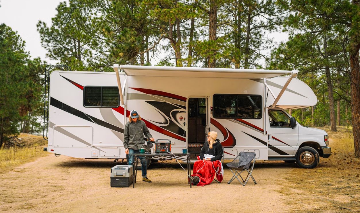 a group of people outside of a camper