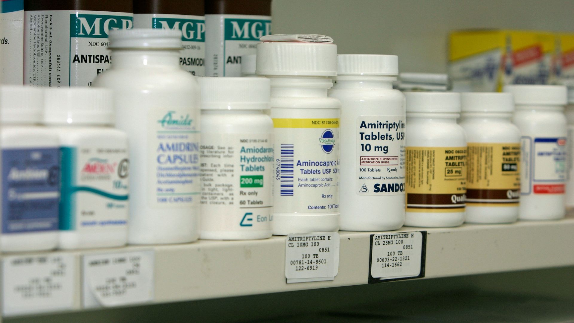 a pharmacy shelf filled with lots of medicine bottles