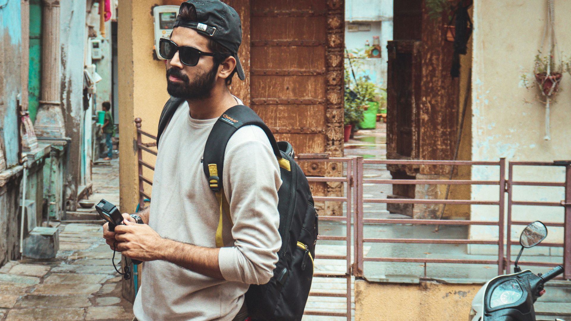 a man walking down a street holding a cell phone