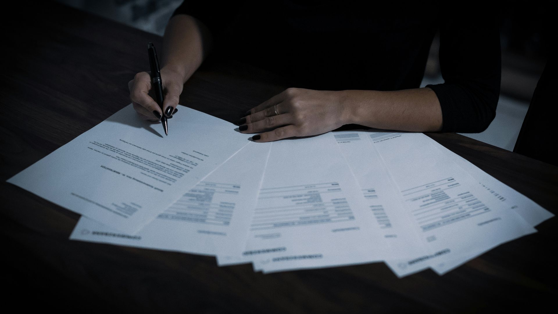 a woman sitting at a table with lots of papers