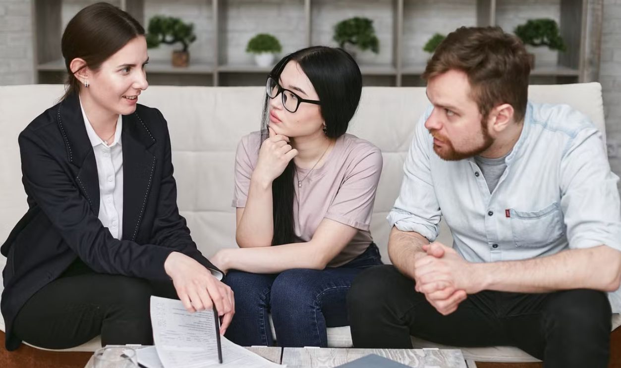 Three adults discussing business inside, focused on cooperation and strategy