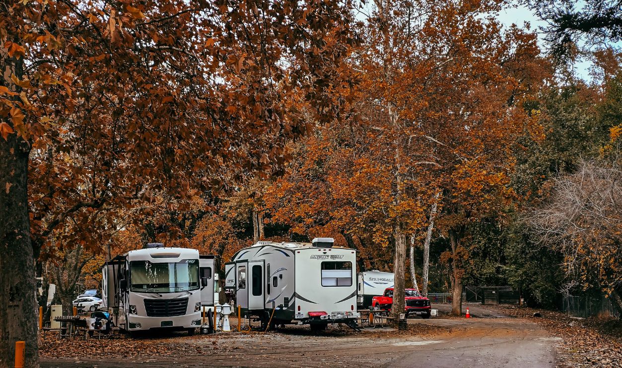 Cozy RV campsite surrounded by vibrant fall foliage in a serene forest