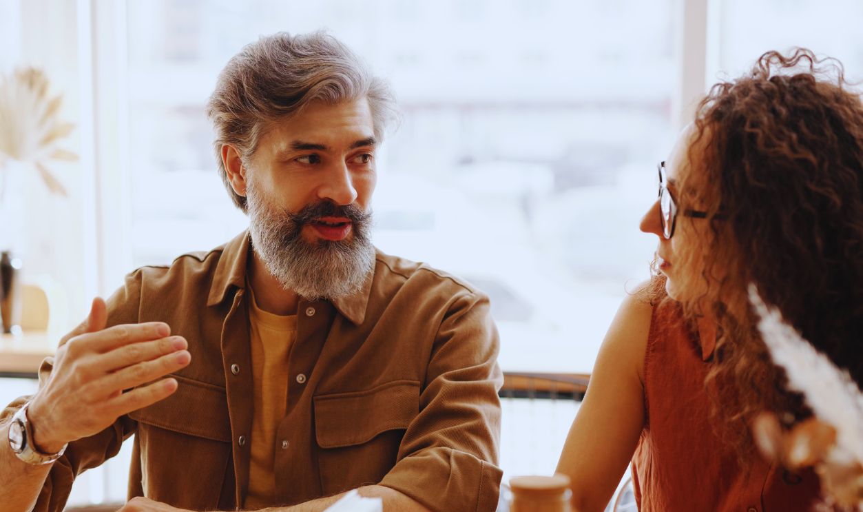 A friendly discussion among colleagues in a cozy cafe environment, fostering teamwork and collaboration