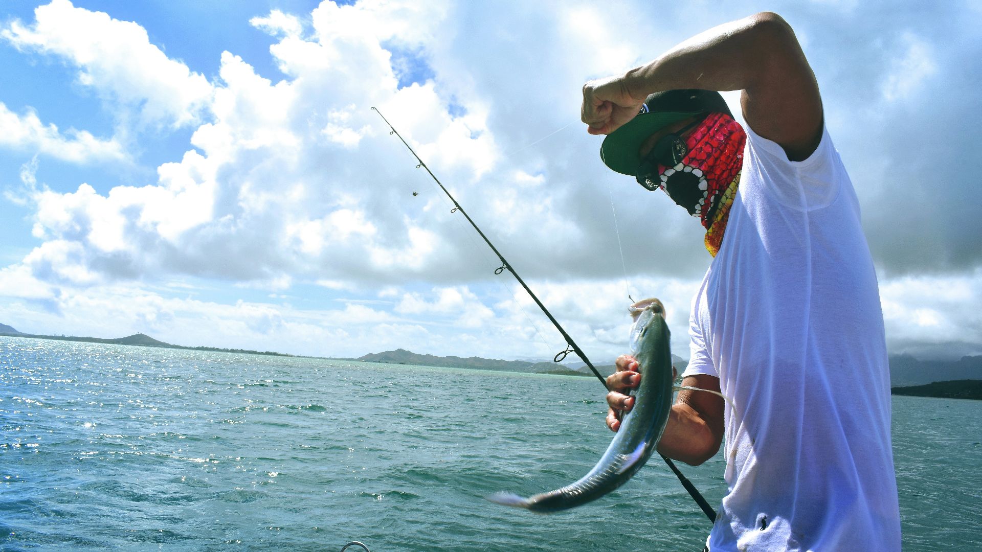 man in white t-shirt holding a fish