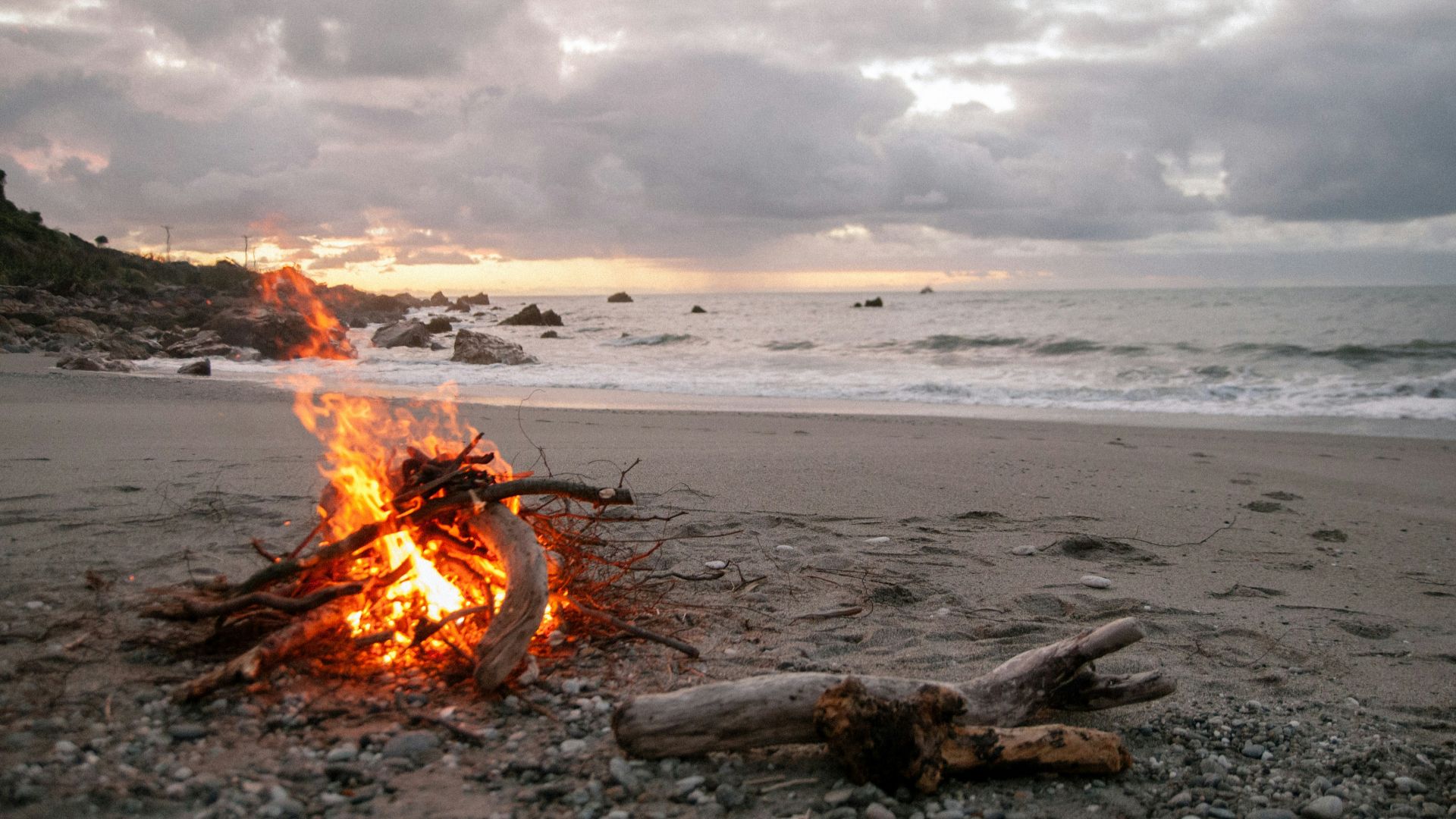 bonfire on shore near body of water