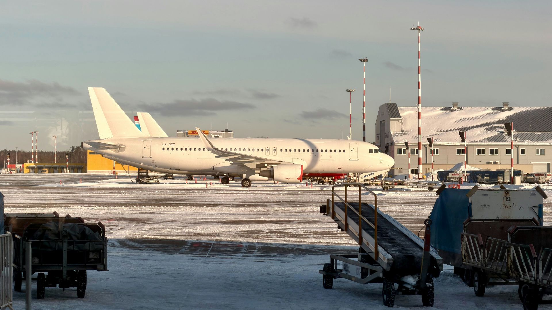 White airplane on a snowy airport tarmac.